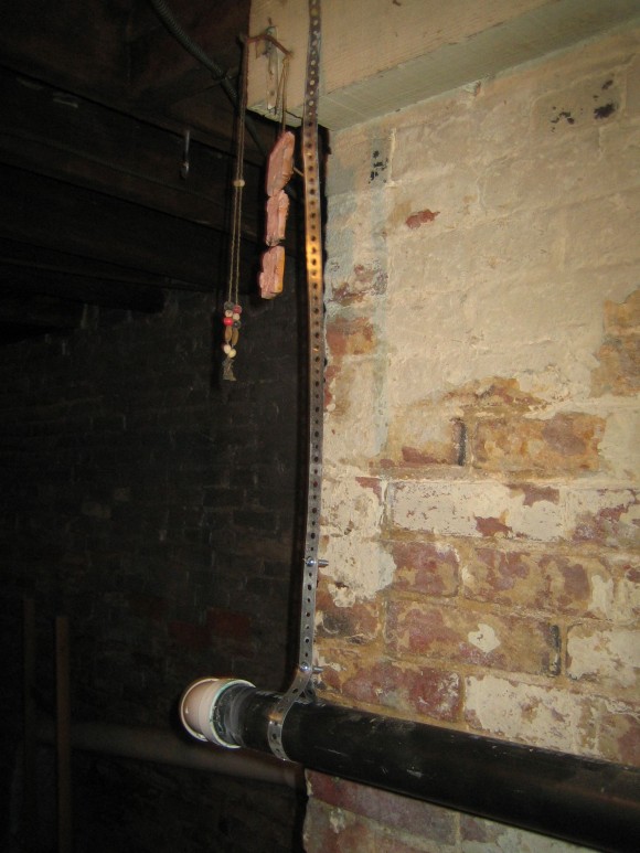 Random metal straps suspended from the ceiling and decorated with clay figurines